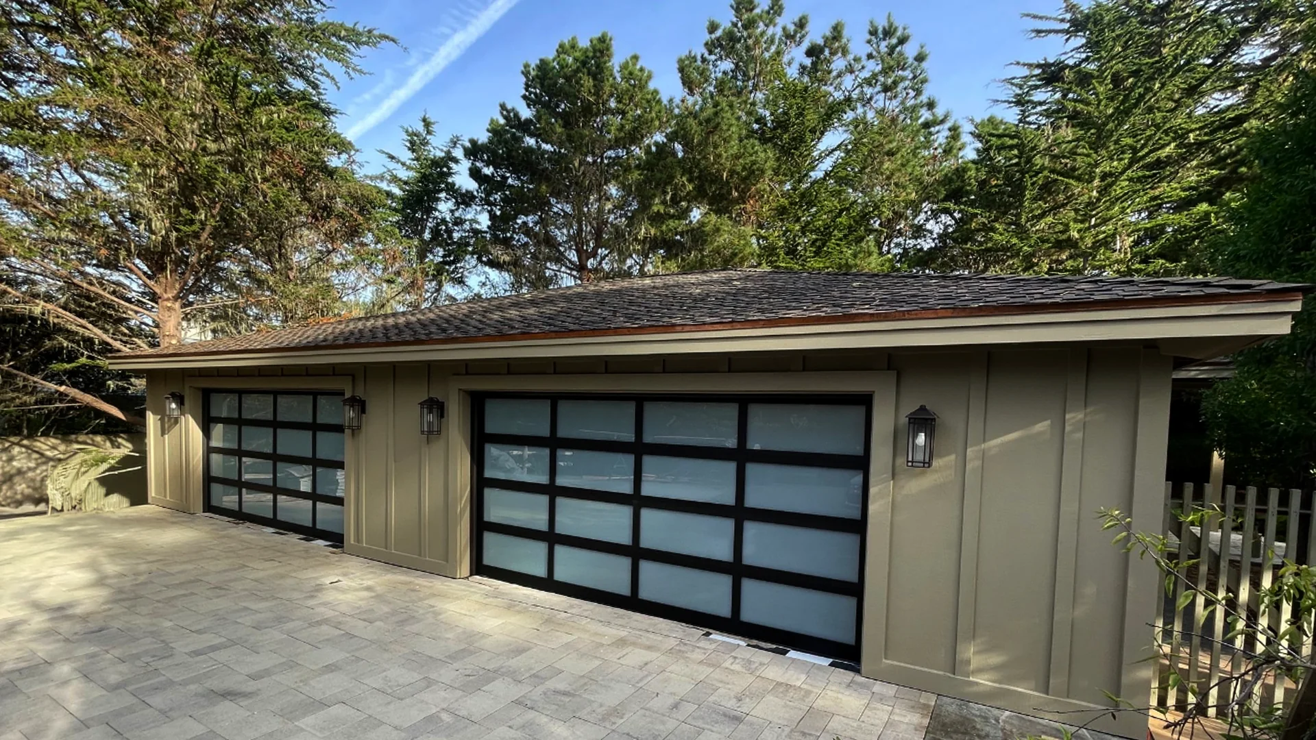 Modern glass garage doors on cobblestone