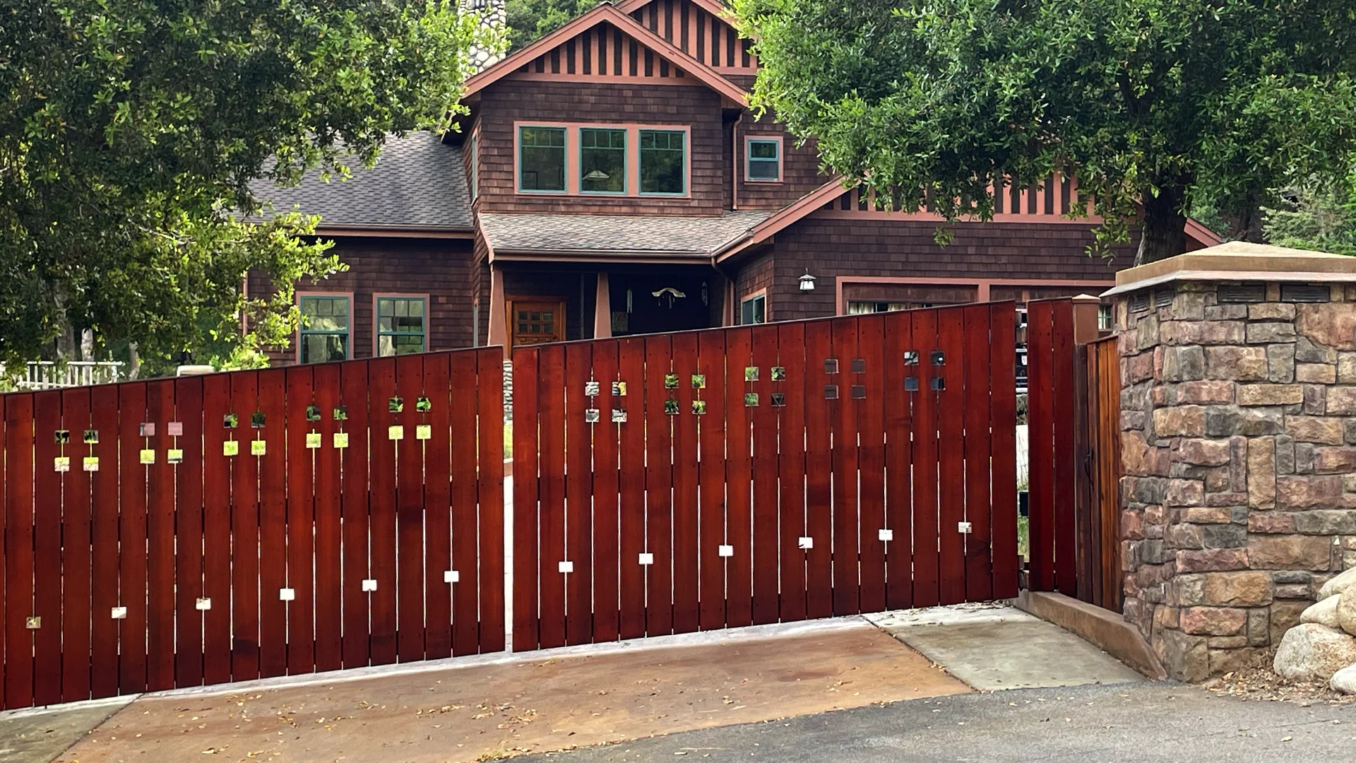 Cedar gate with stone pillars and Craftsman house beyond